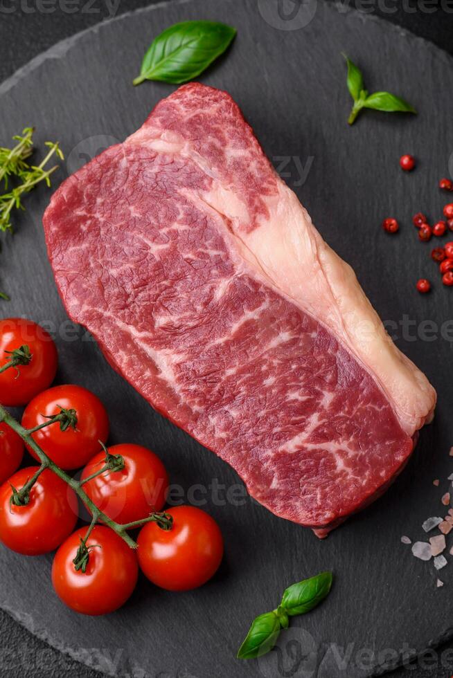 färsk rå nötkött ryggbiffen biff med salt, kryddor och örter foto