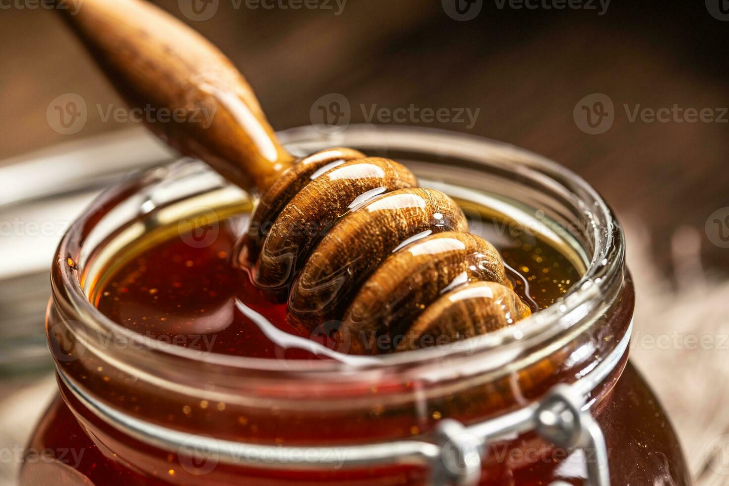 burk av honung med dipper på trä- tabell - närbild foto