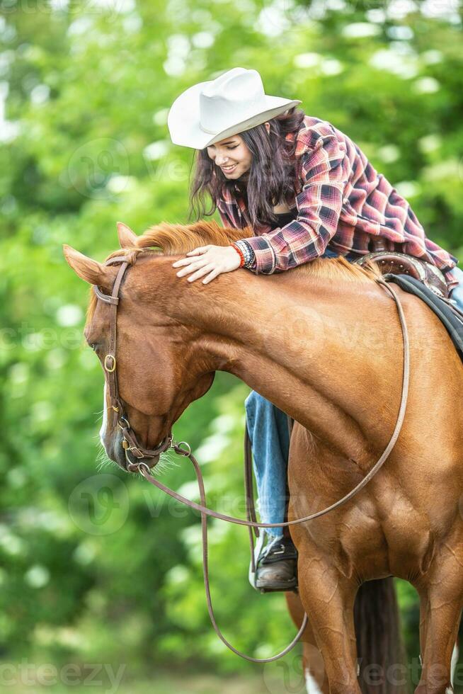 flicka klappa en häst den där utseende tillbaka under en sommar natur rida foto