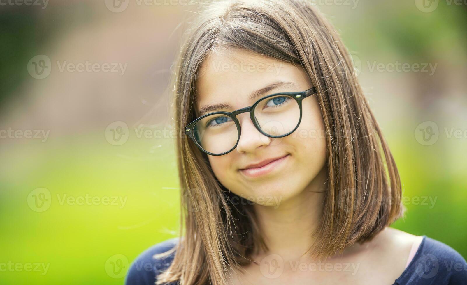 porträtt av en vacker smilling Tonårs flicka med glasögon foto