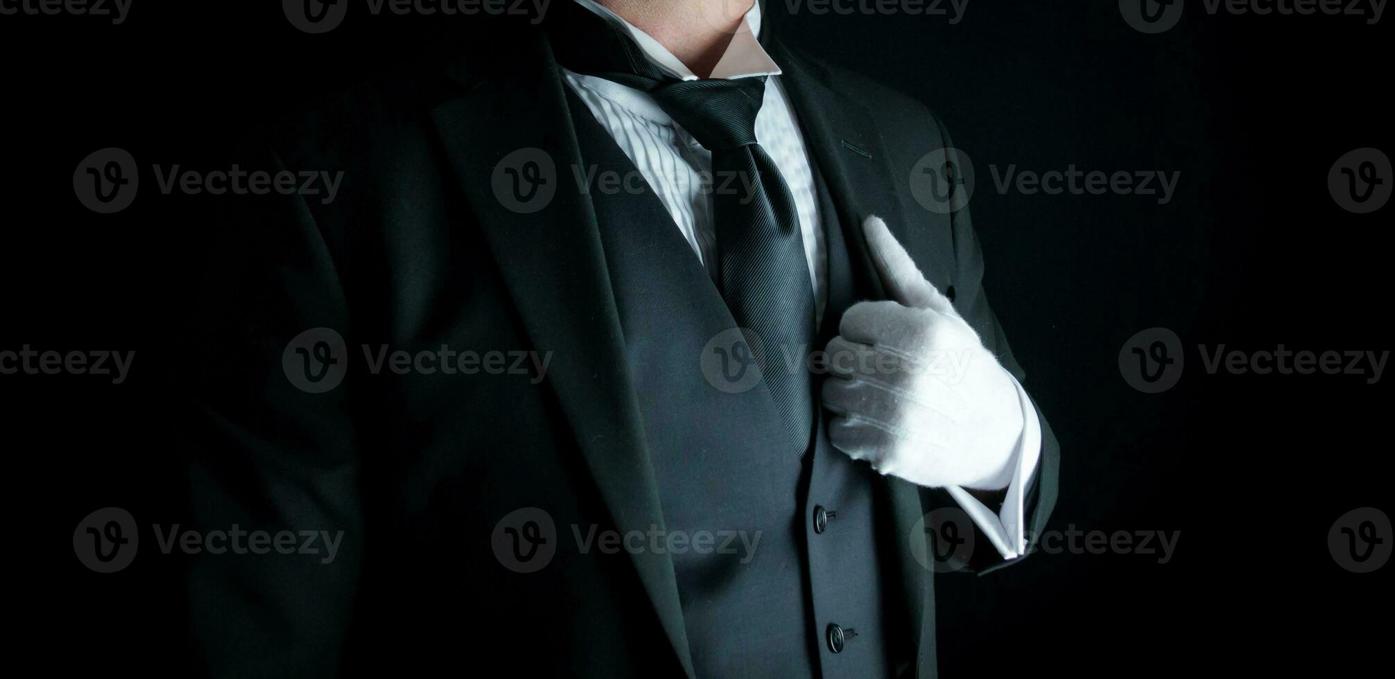 isolerat närbild av butler i mörk kostym och vit handskar stående på värdig uppmärksamhet. service industri och professionell gästfrihet. foto