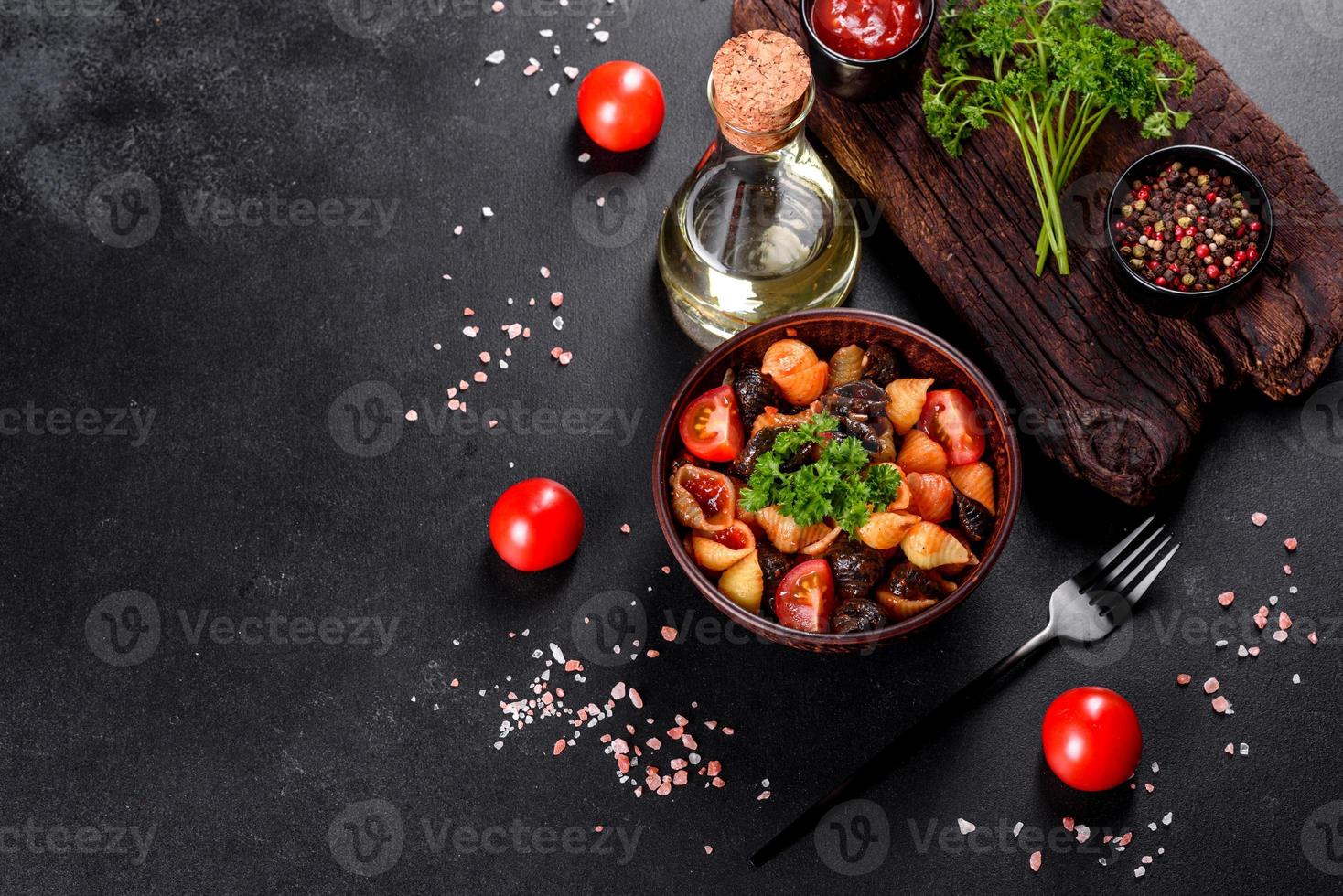 läcker färsk pasta med tomatsås med kryddor och örter på en mörk bakgrund foto