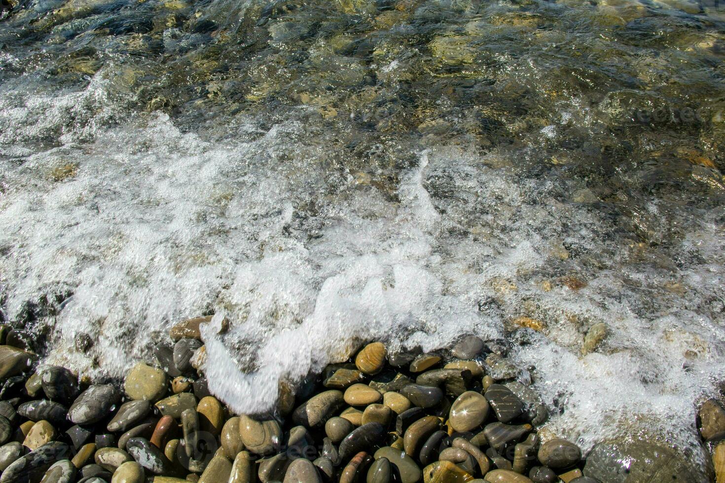 hav och småsten under vattnet i en strand. sten bakgrund foto