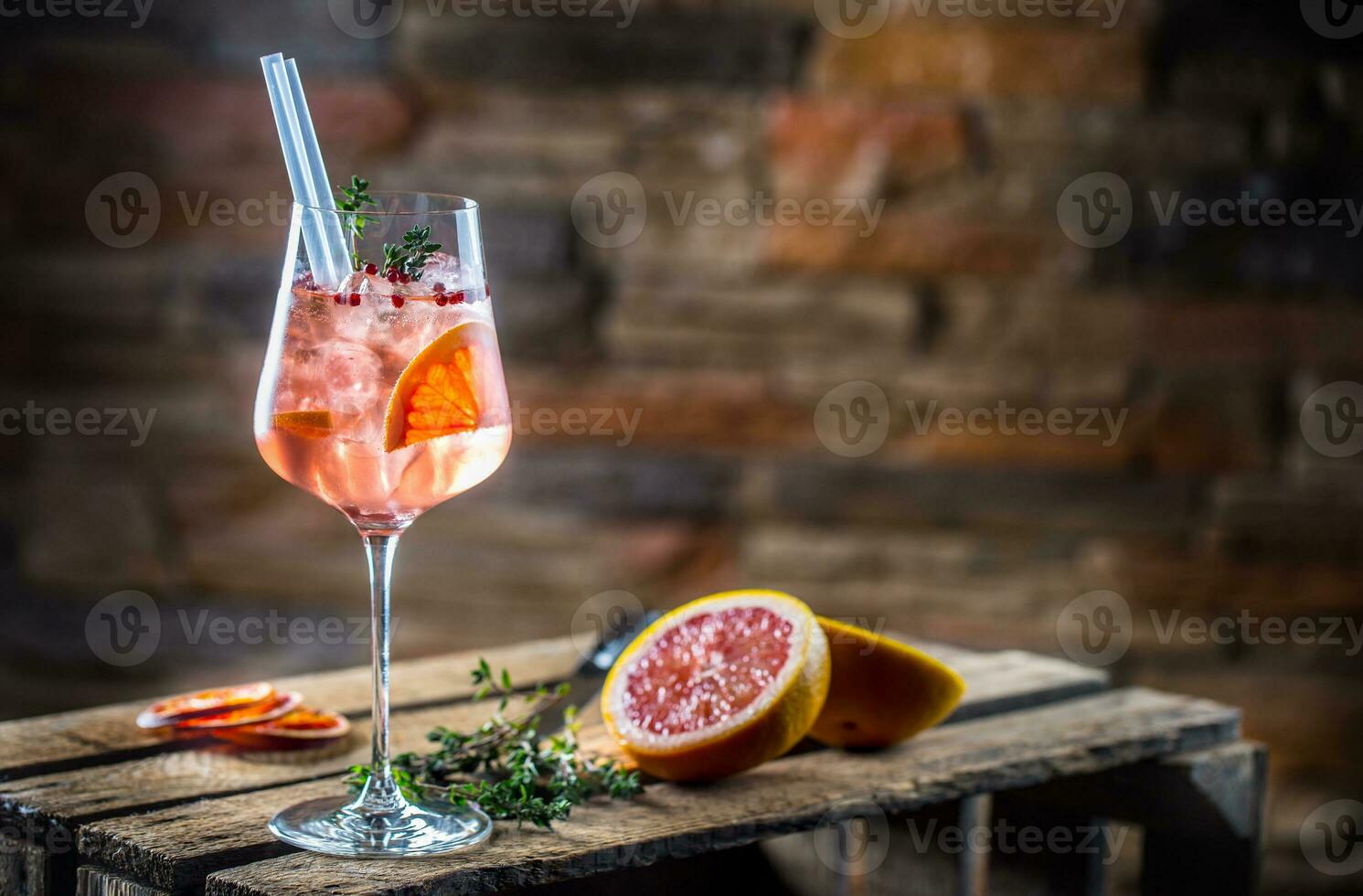 cocktail dryck på en gammal trä- styrelse. alkoholhaltig dryck med tropisk frukt röd peppar ört och is foto