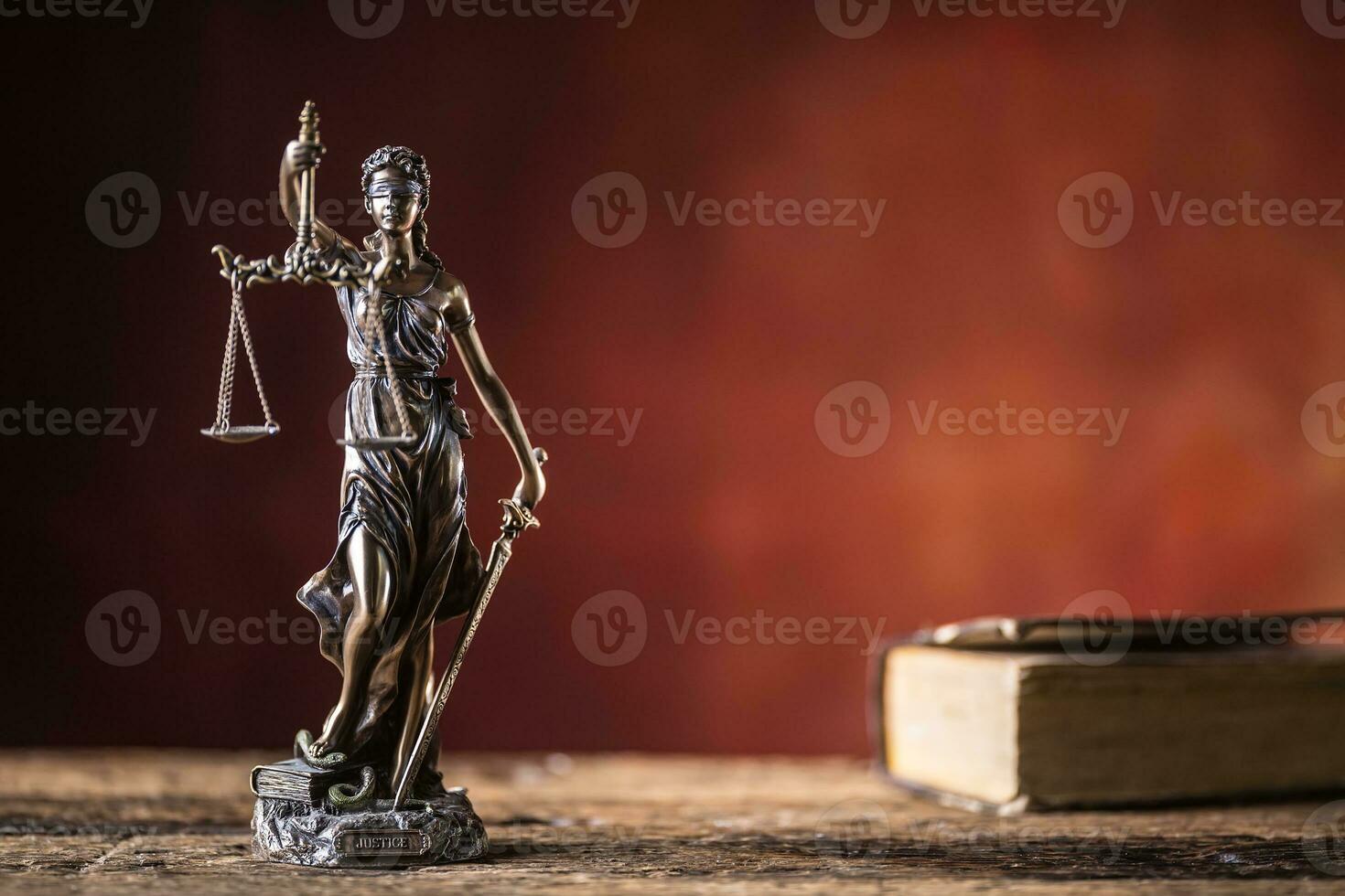 lady justicia innehav svärd och skala brons statyett med bok på trä- tabell foto