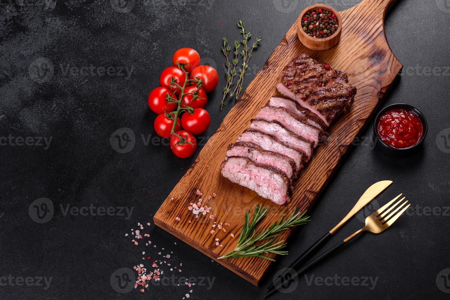 färsk saftig läcker nötköttbiff på en mörk bakgrund foto