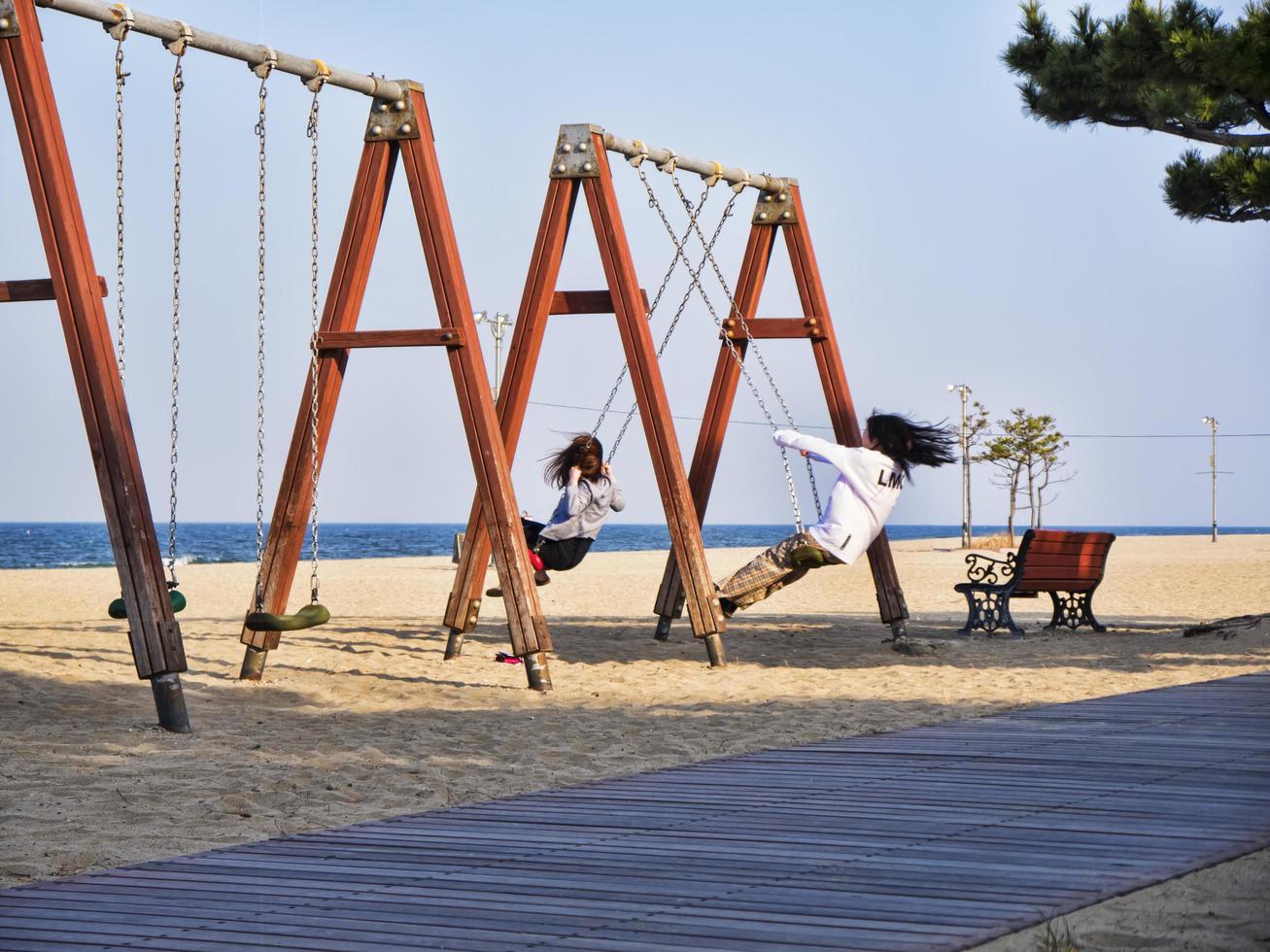 flickor på gungor på stranden i Yangyang City, Sydkorea foto