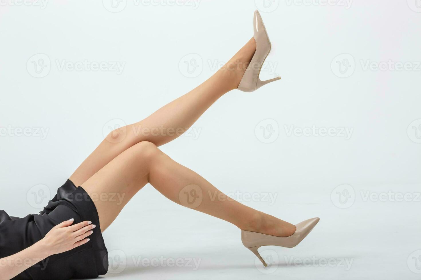 kvinna liggande på golv med henne lång bar ben med hög hälar foto