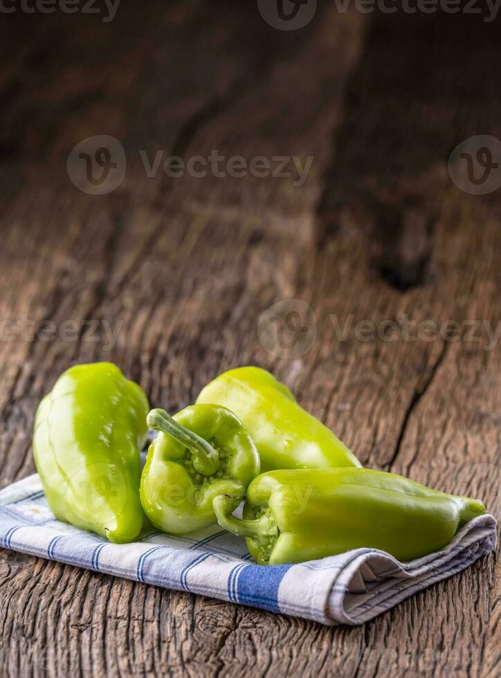 grön peppar.färsk grön peppar blå rutig bordsduk på gammal ek tabell. foto