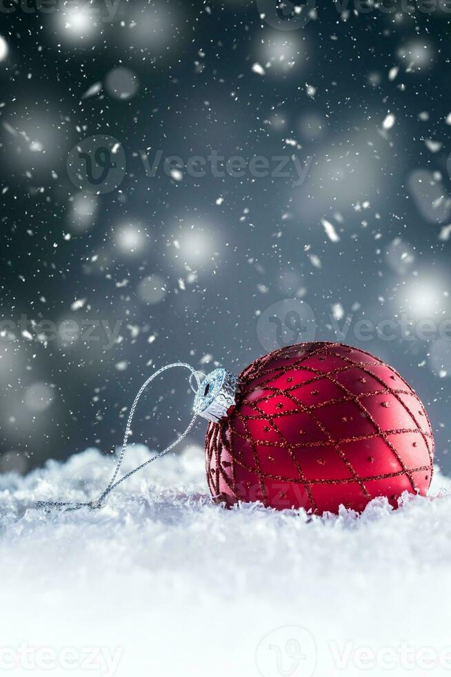 jul röd lyx boll i snö och abstrakt snöig atmosfär foto