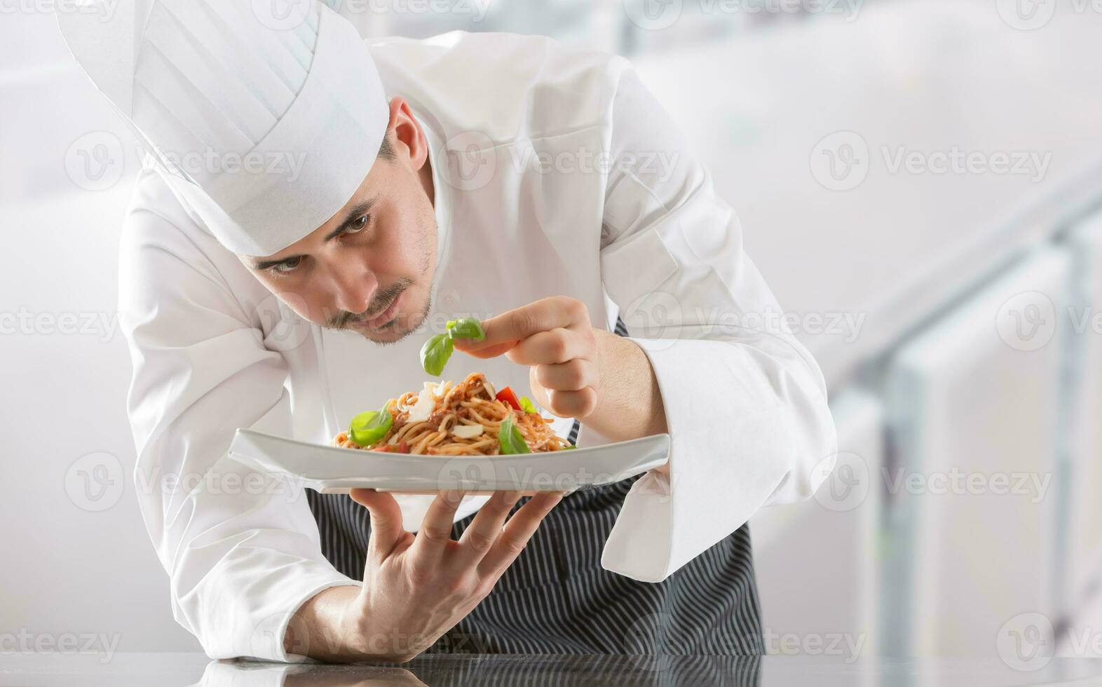 kock i restaurang kök förbereder och dekorerar måltid med händer.koka framställning spaghetti bolognese foto