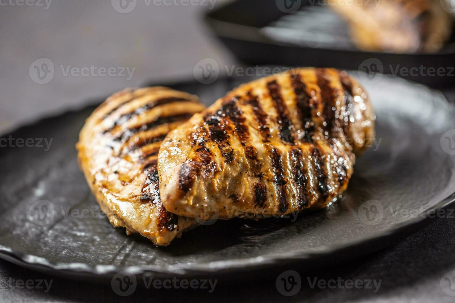 grillad kyckling bröst i svart tallrik på kök tabell foto