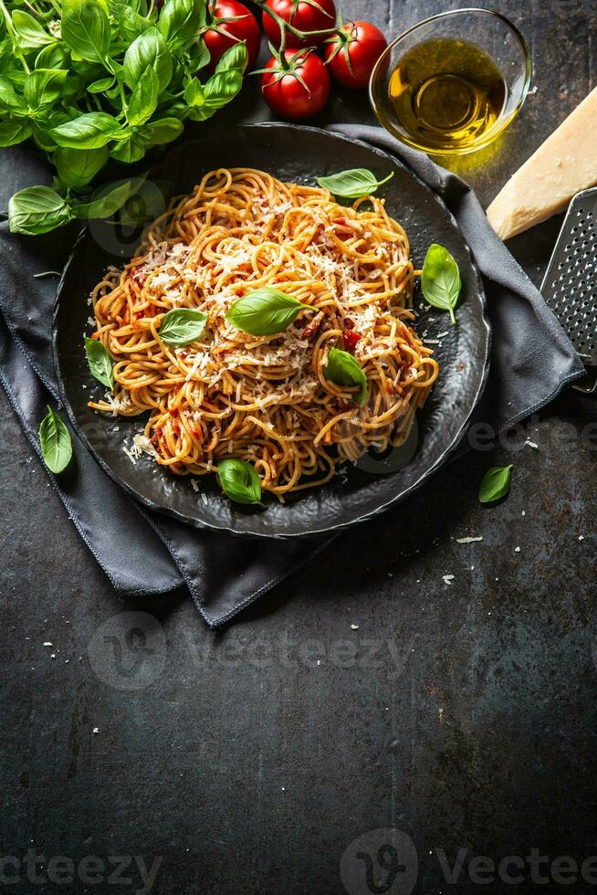 pasta spaghetti toamto och bolognese sås med oilve olja parmesan och basilika foto