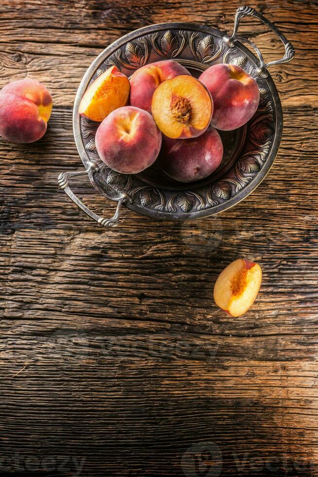 mogen persikor i rustik skål och trä- tabell foto
