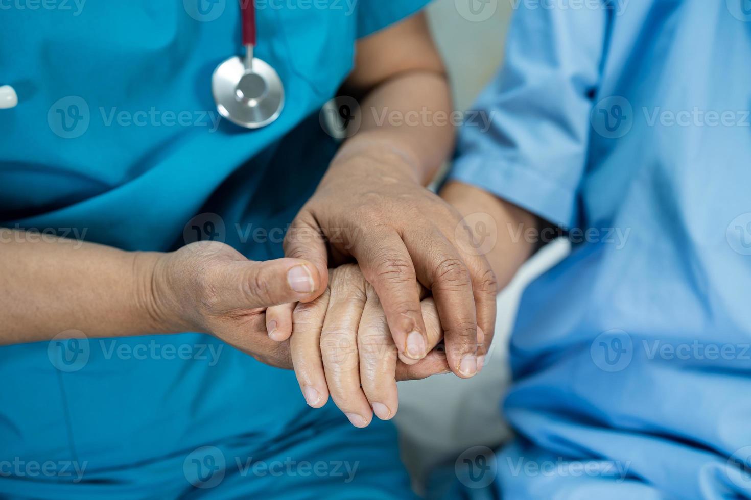 läkare som håller händerna asiatiska äldre eller äldre gammal dam kvinna patient med kärlek, vård, uppmuntrar och empati på vårdavdelningen, hälsosamt starkt medicinskt koncept foto