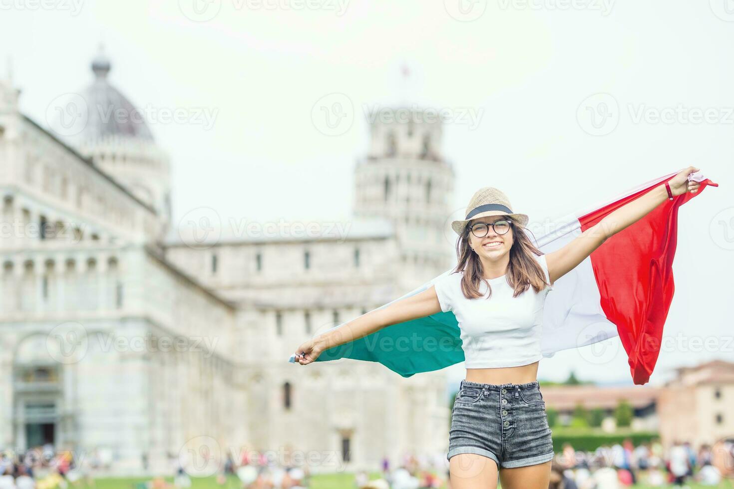 ung tonåring flicka resande med italiensk flagga innan de historisk torn i stad pisa - Italien foto