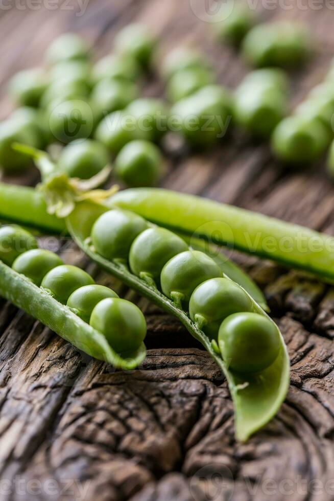 ärtor. färsk bio hemlagad ärtor och skida på gammal ek styrelse. friska färsk grön vegetabiliska - ärtor och baljor. foto