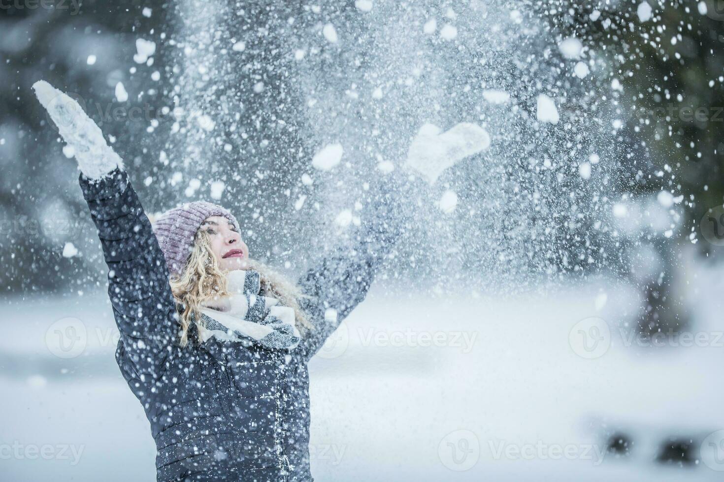 ung kvinna i värma kläder är har roligt ut av de snö foto