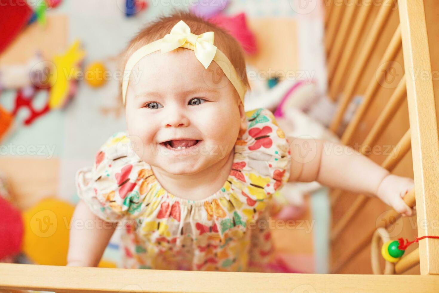 en bebis ler medan stående i en spjälsäng foto