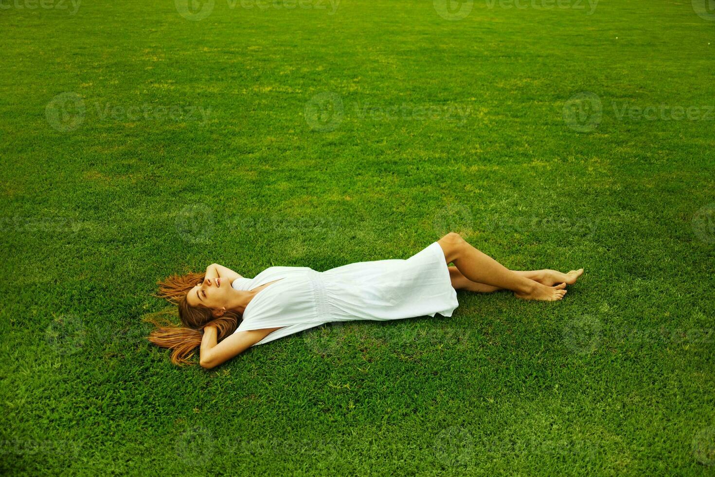 en kvinna om på de gräs i en vit klänning foto