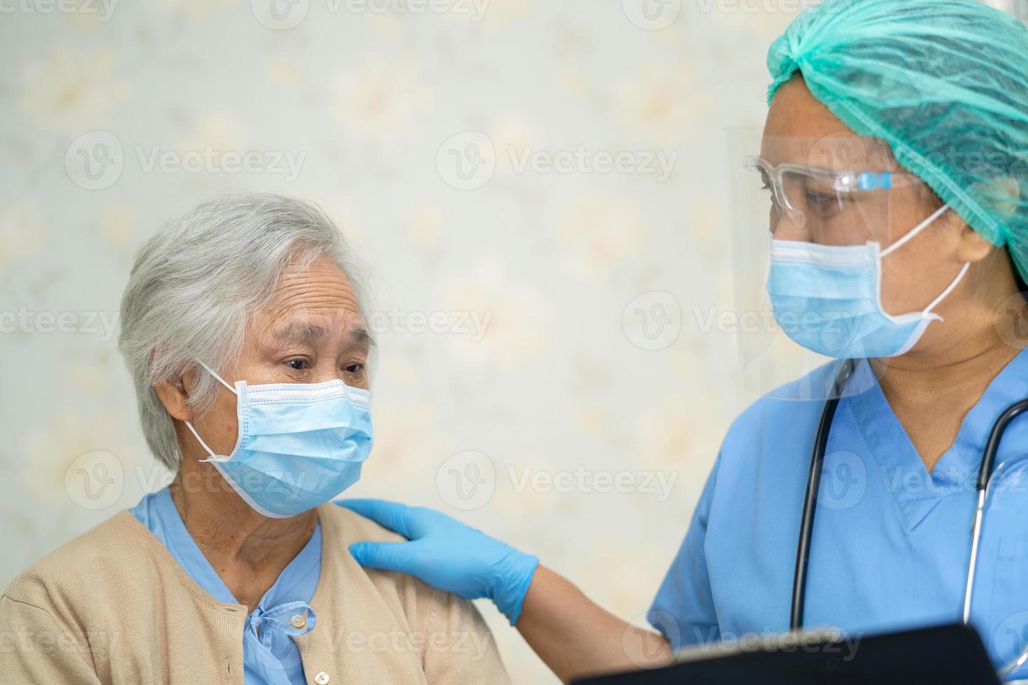 asiatisk läkare som bär ansiktsskydd och folkdräkt nytt normalt för att kontrollera patientens skydd infektion covid-19 koronavirusutbrott vid karantän vårdavdelningen. covid, positiv, patient, sjuksköterska, corona, new normal, sjukdom, ppe, foto