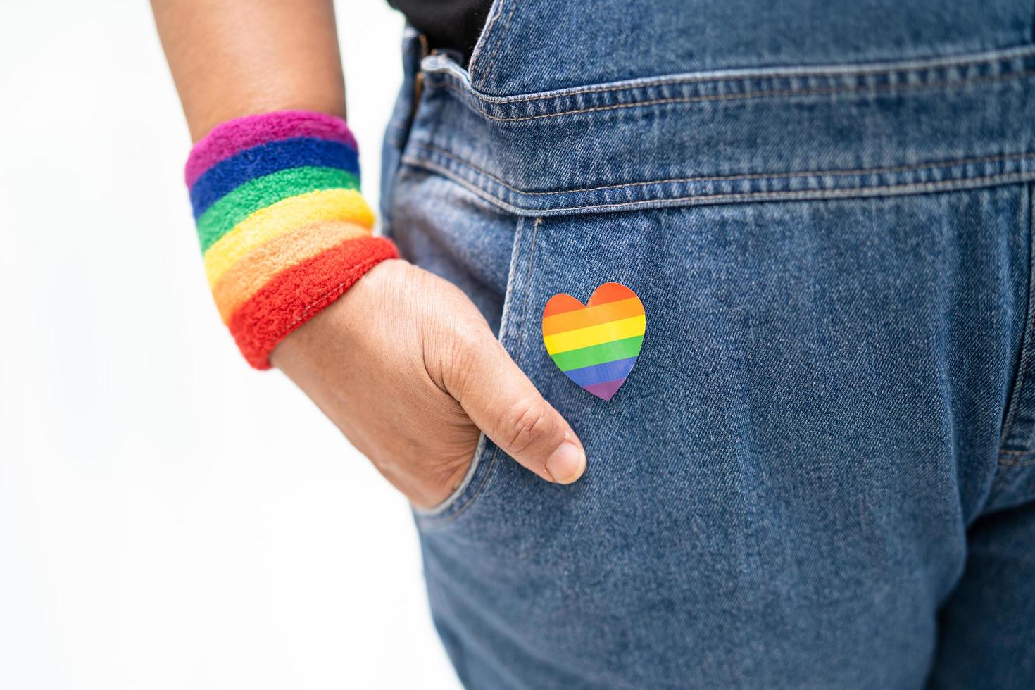 asiatisk dam som bär regnbågsflaggarmband, symbol för HBT stolthet månad firar årliga i juni sociala av homosexuella, lesbiska, bisexuella, transpersoner, mänskliga rättigheter. foto