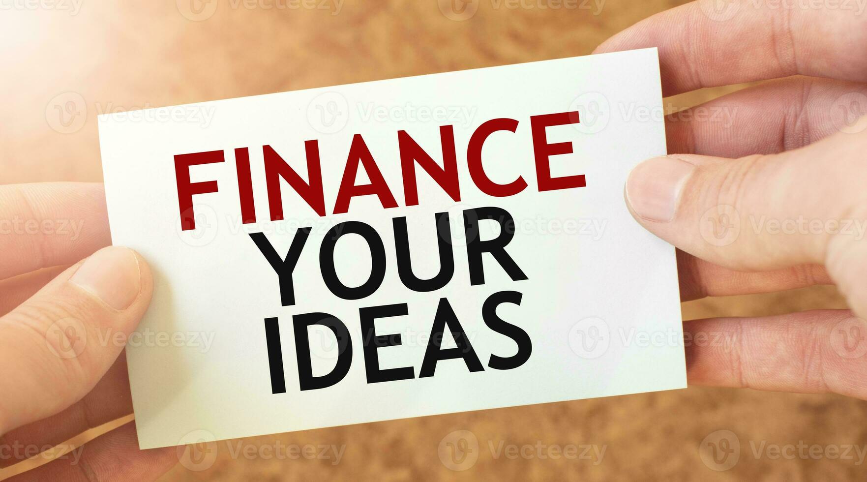 finansiera din idéer ord inskrift på vit kort papper ark i händer av en affärsman. foto