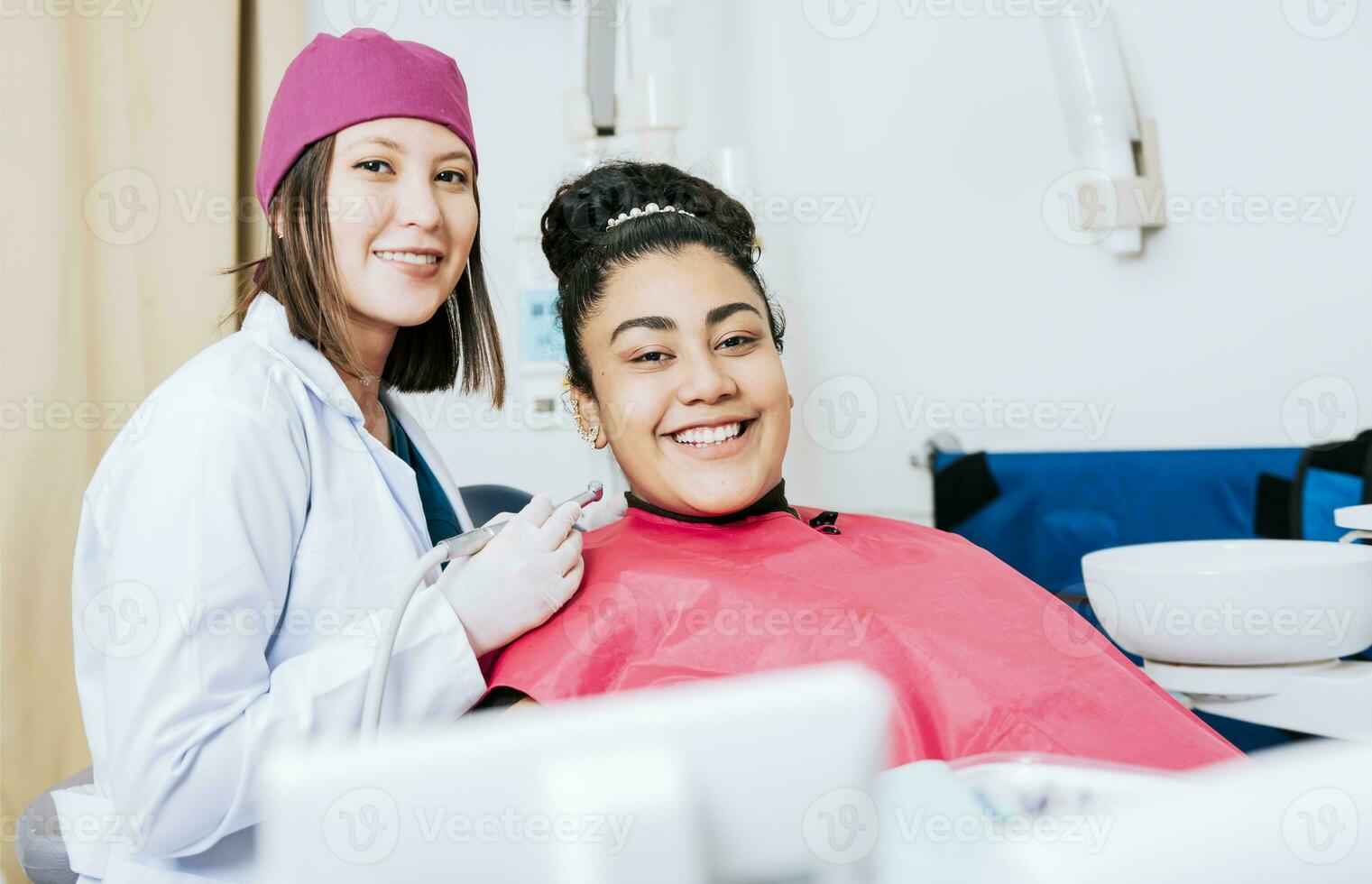 porträtt av leende tandläkare med kvinna patient i medicinsk kontor, kvinna tandläkare med leende kvinna patient ser på kamera, professionell tandläkare med kvinna patient i kontor foto