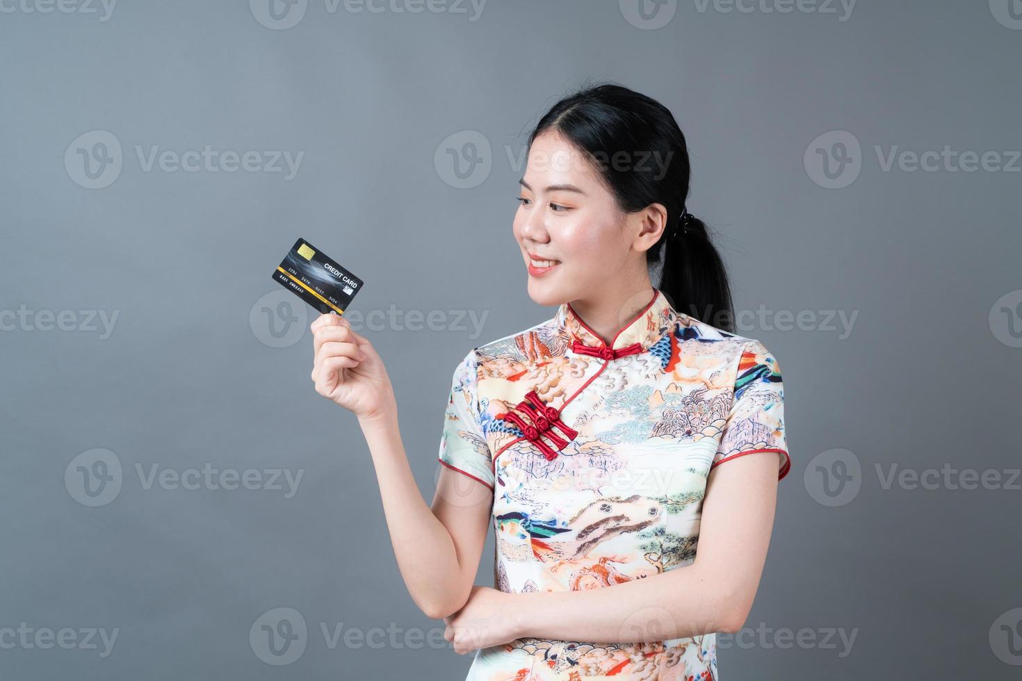 asiatisk kvinnakläder kinesisk traditionell klänning med handinnehavkreditkort foto