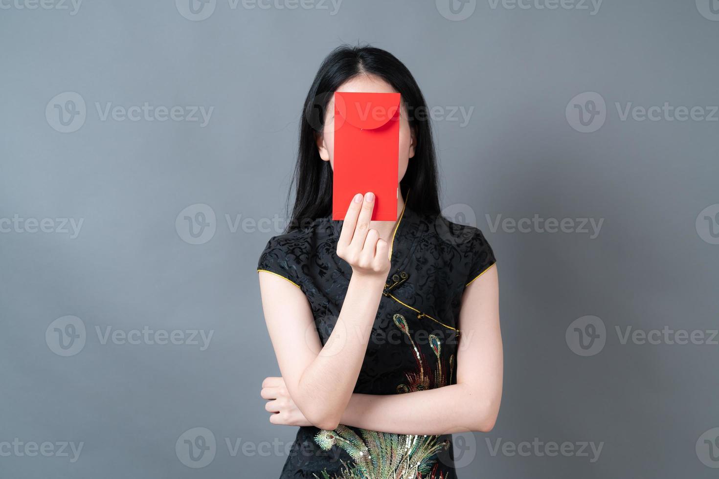 asiatisk kvinna bär kinesisk traditionell klänning med rött kuvert eller rött paket foto