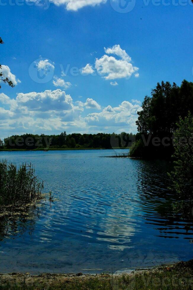 sommar idyllisk landskap med en sjö under en blå himmel på en värma solig dag foto