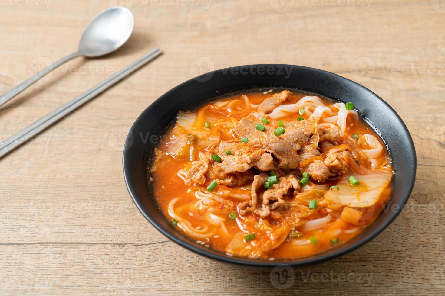 koreanska udon ramen nudlar med fläsk i kimchi soppa foto