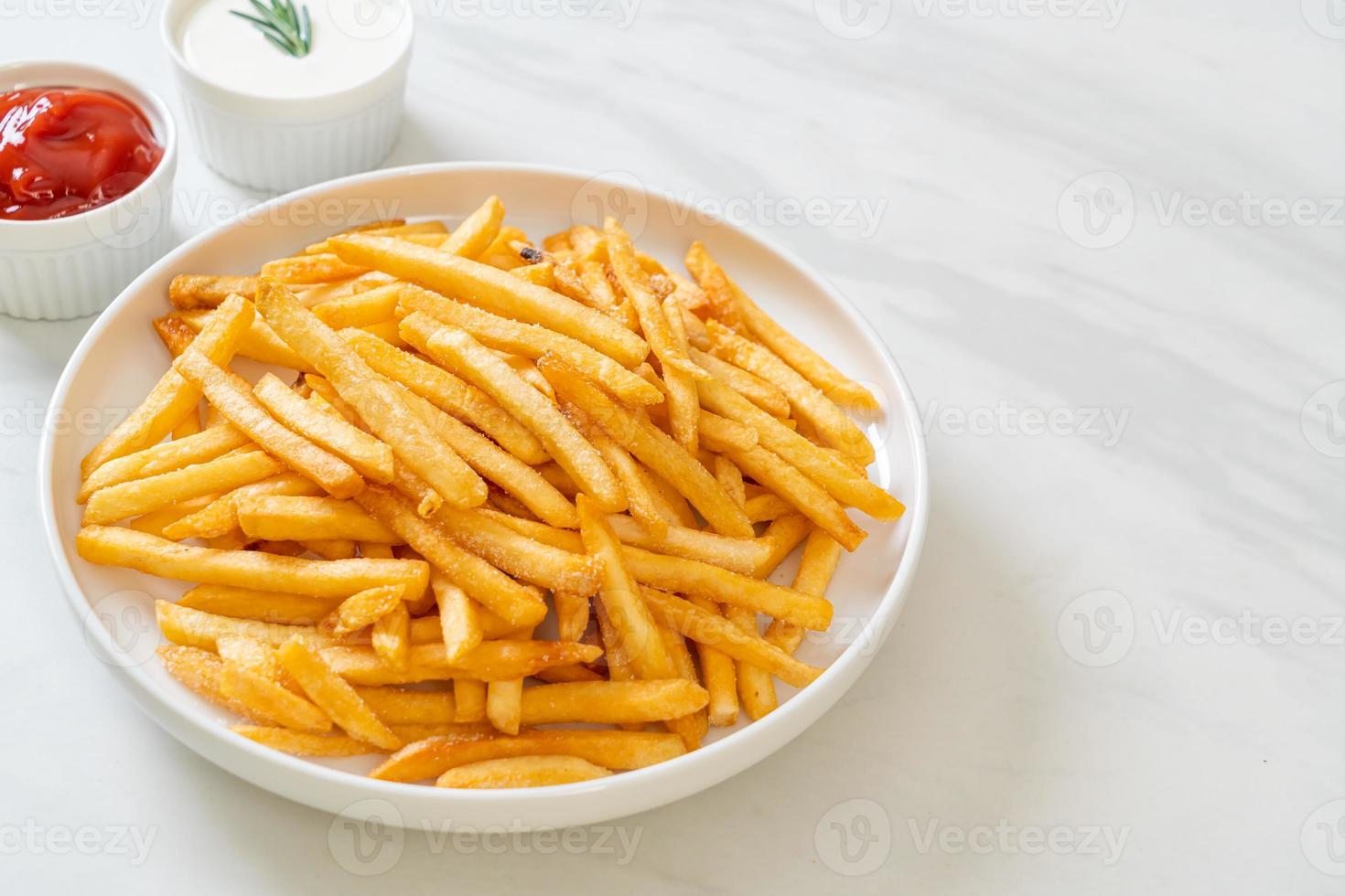 pommes frites med gräddfil och ketchup foto