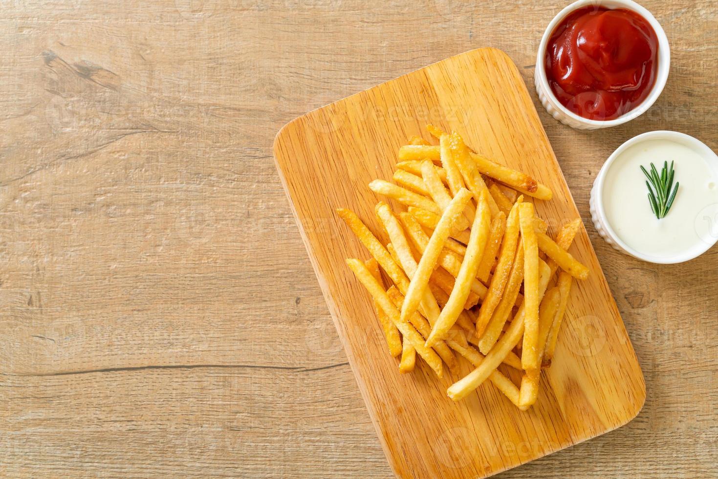 pommes frites med gräddfil och ketchup foto