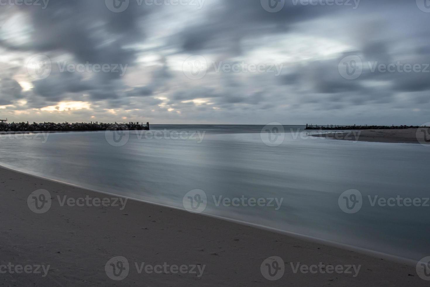 flodmynningen av floden sventoji skyddad av gamla vågbrytare byggd av trä och stenar vid Litauens kust av Östersjön foto