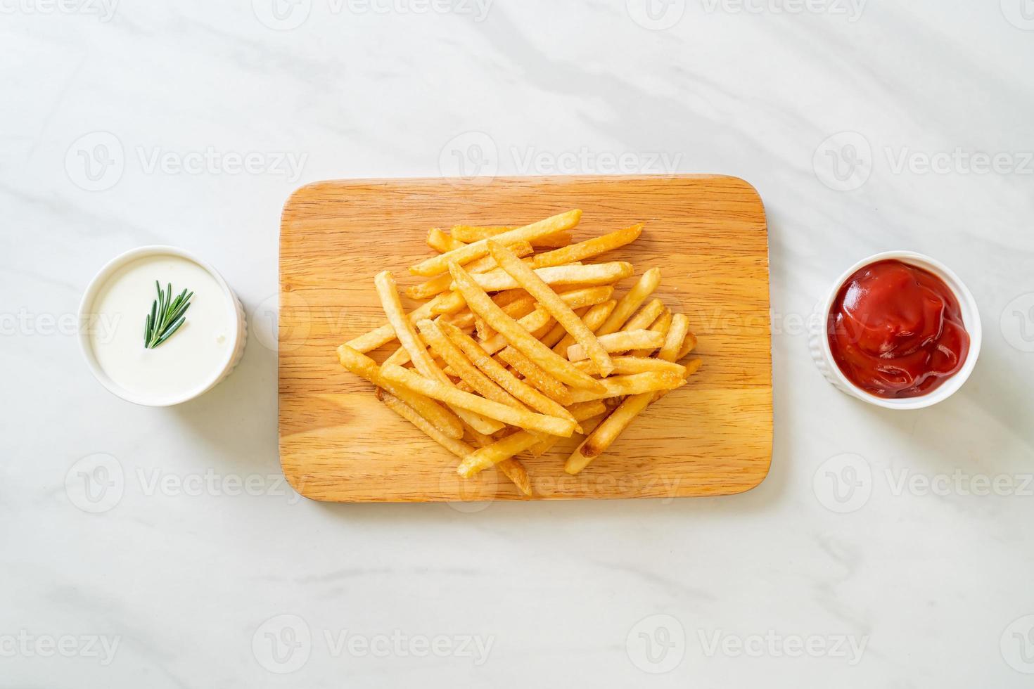 pommes frites med gräddfil och ketchup foto