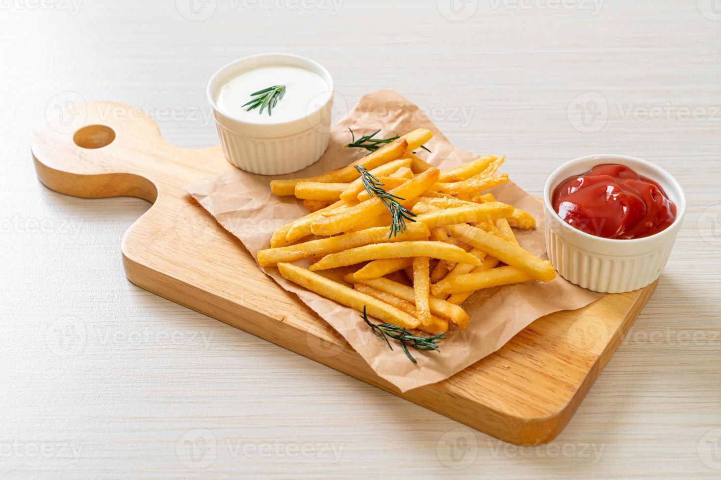 pommes frites med gräddfil och ketchup foto