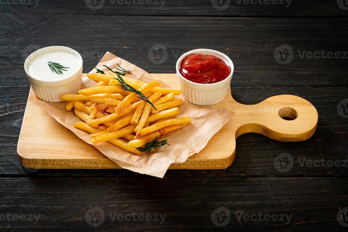 pommes frites med gräddfil och ketchup foto