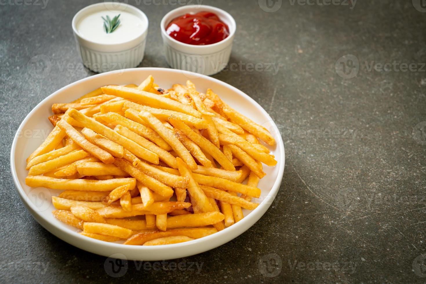 pommes frites med gräddfil och ketchup foto