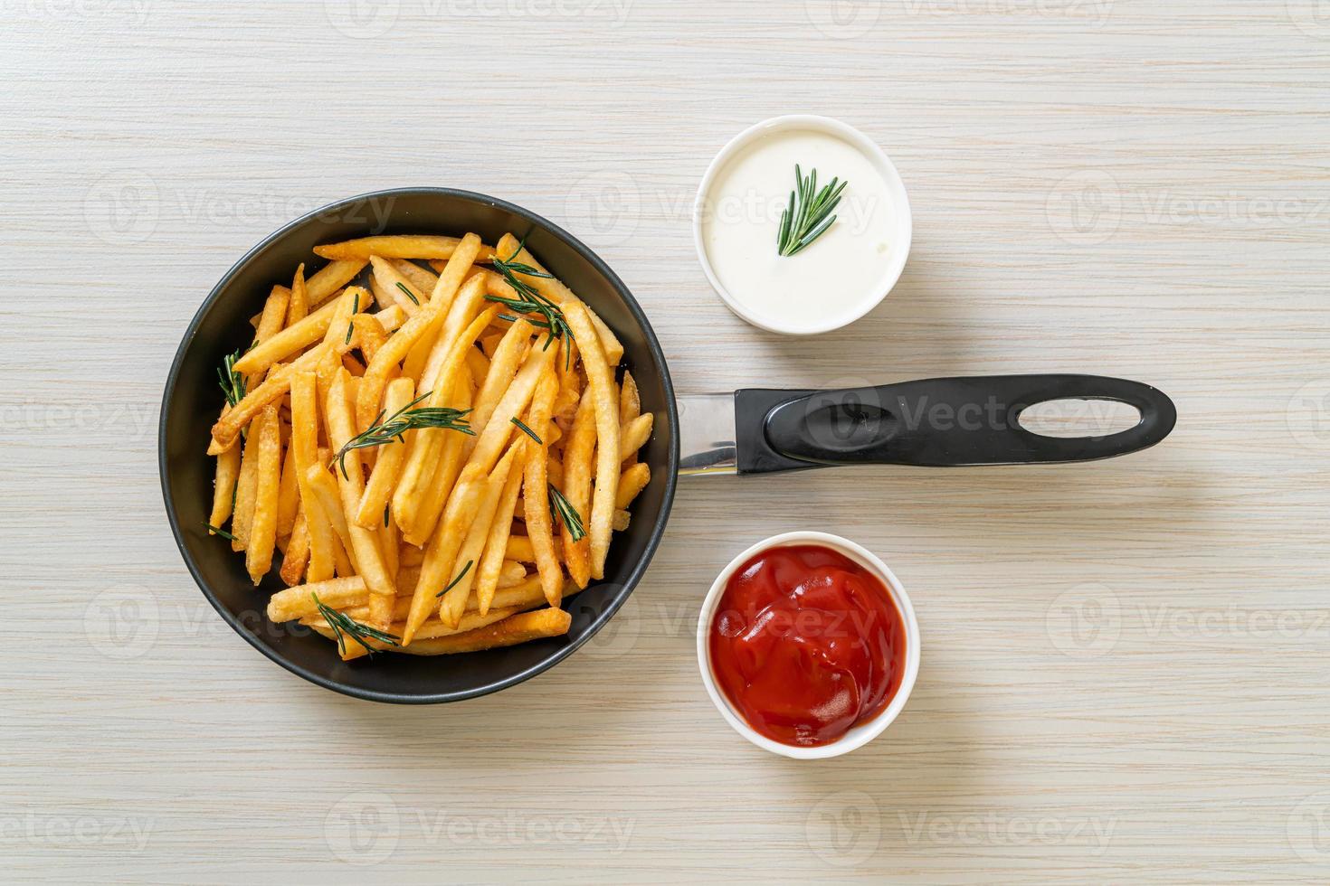 pommes frites med gräddfil och ketchup foto