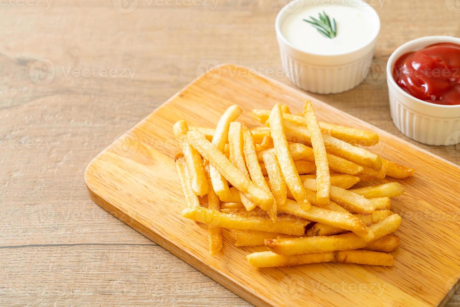 pommes frites med gräddfil och ketchup foto