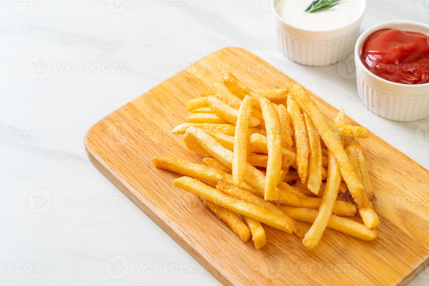 pommes frites med gräddfil och ketchup foto