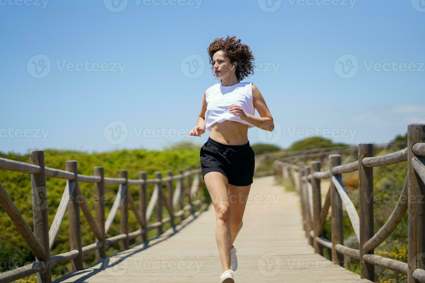 sports löpning längs trä- väg på solig dag foto