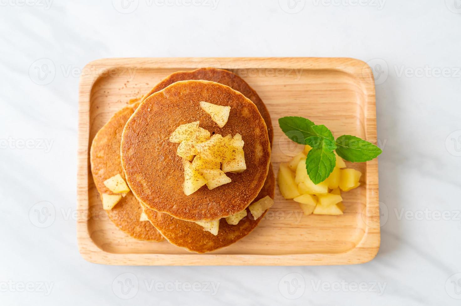 äppelpannkaka eller äppelkrepa med kanelpulver foto