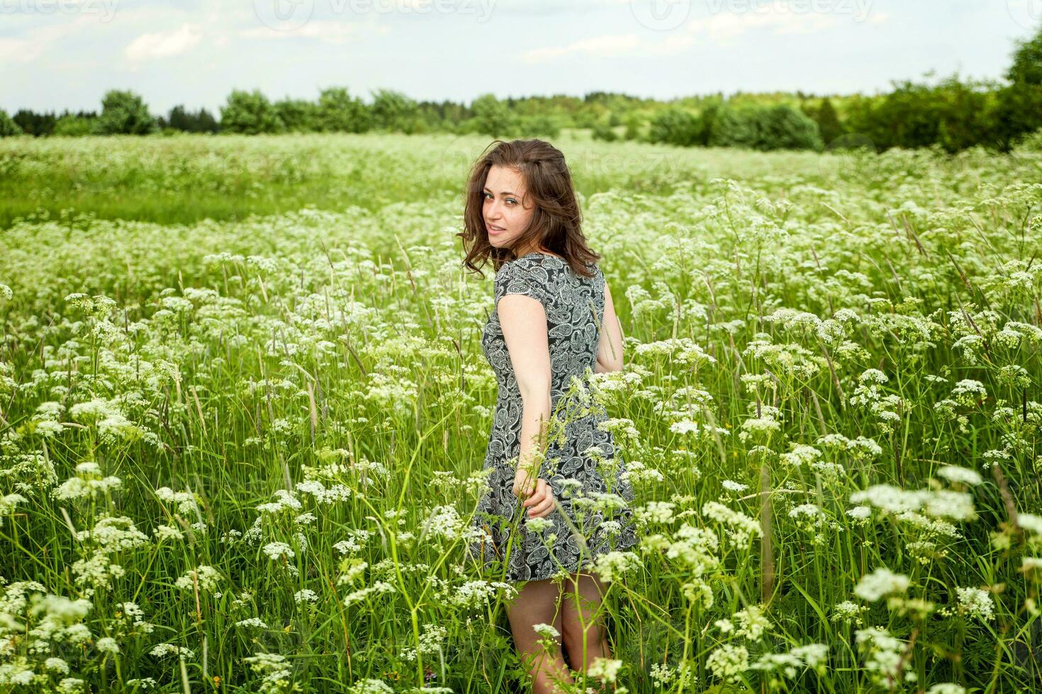 skönhet flicka utomhus njuter natur. skön kvinna Hoppar på sommar fält med blomning vild blommor, Sol ljus. fri Lycklig kvinna. foto