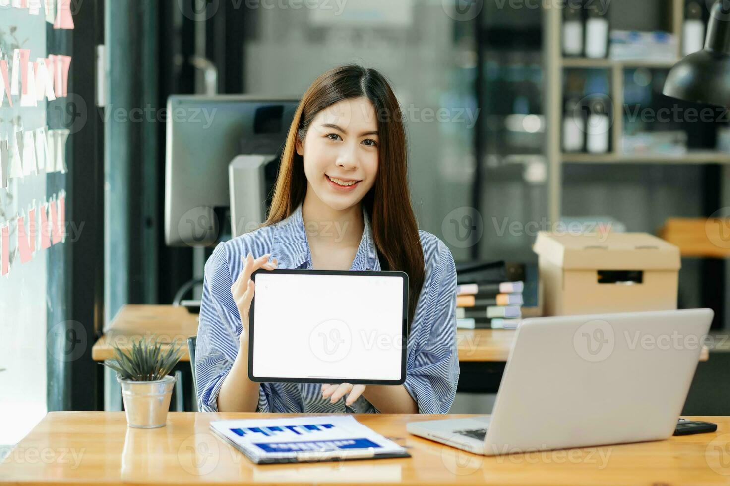 ung kvinna använder sig av och ser på attrapp bärbar dator dator på trä- tabell tillsammans på kontor skrivbord med klippning väg läsplatta foto