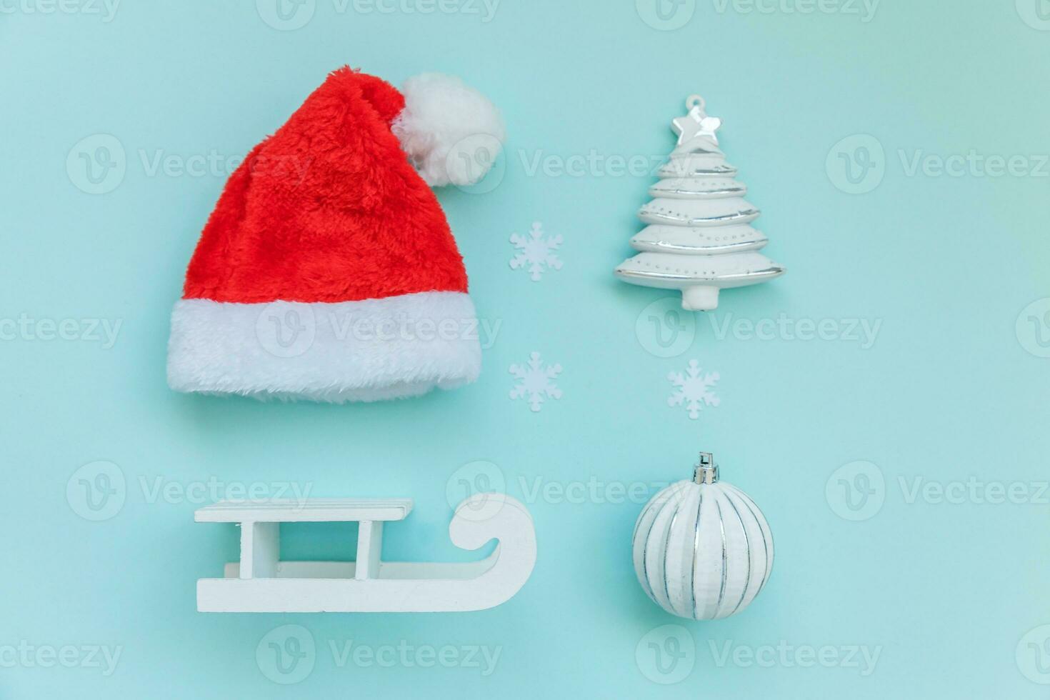 helt enkelt minimal sammansättning vinter- objekt prydnad santa hatt kälke gran träd boll isolerat på blå pastell trendig bakgrund foto