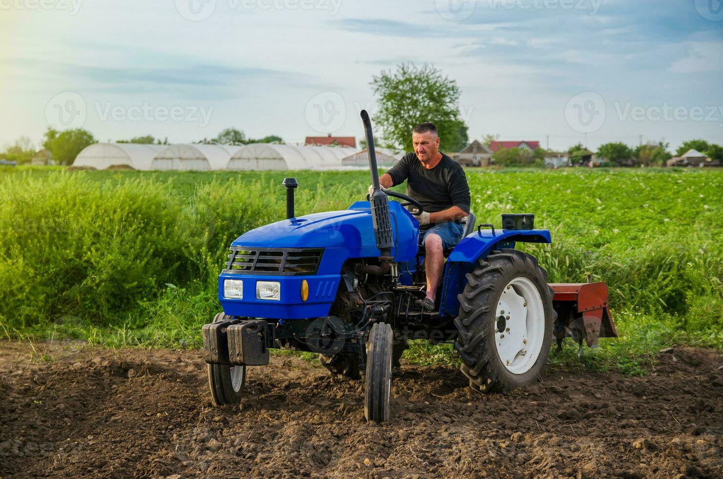 jordbrukare rider en traktor tvärs över de fält. fräsning jord. arbete i de fält och förberedelse av de landa för plantering av plantor eller frön. jordbruksnäringen och jordbruksindustrin. lossna , odling. plöjning foto