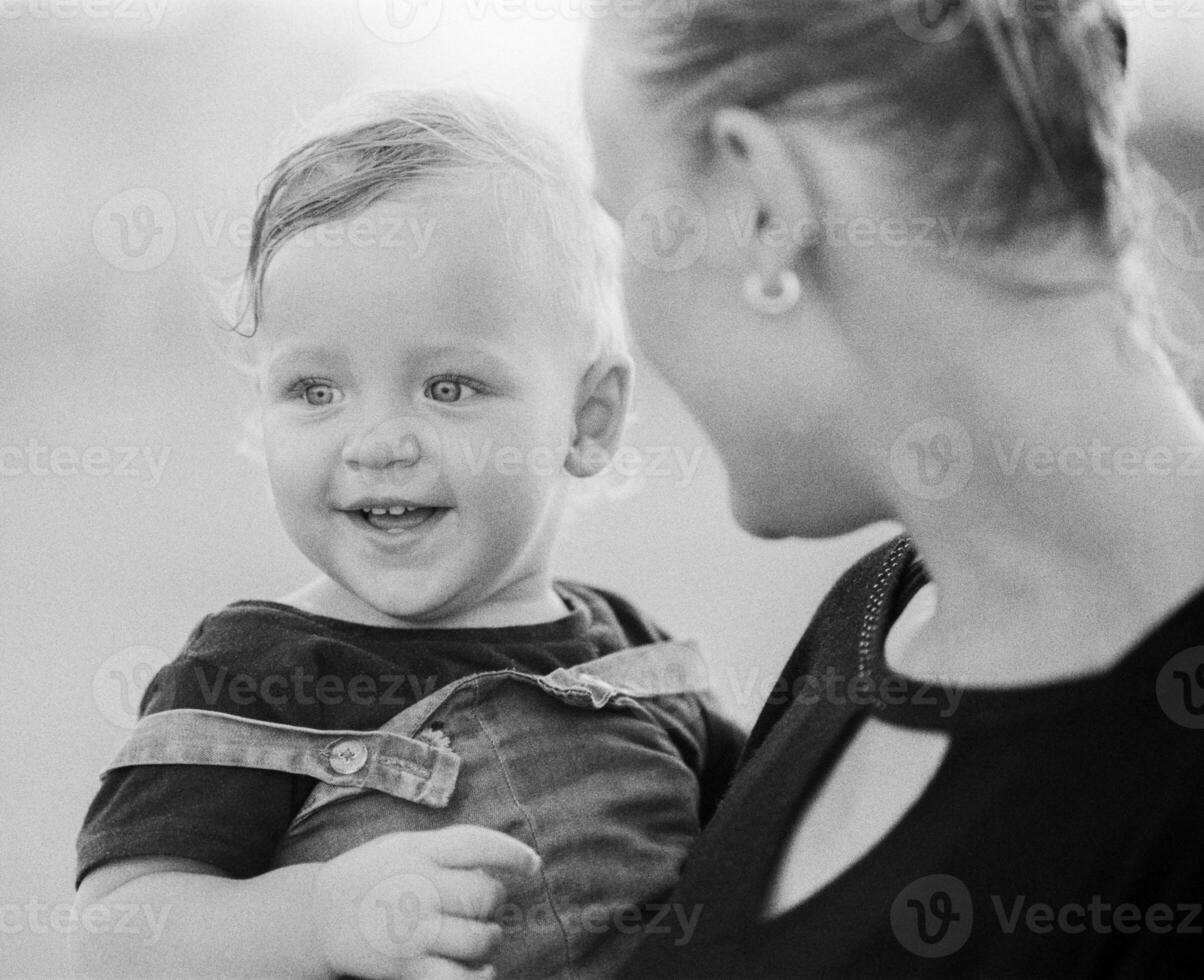 kärleksfull mor med bebis flicka i vapen. svart och vit foto