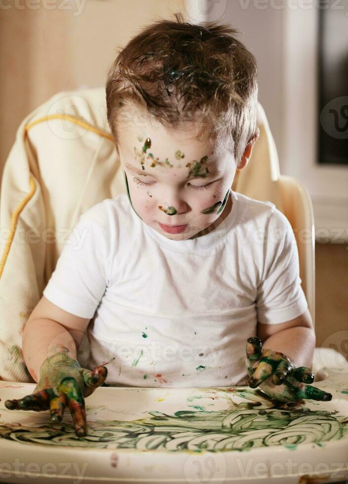 kreativ liten pojke spelar med finger måla foto